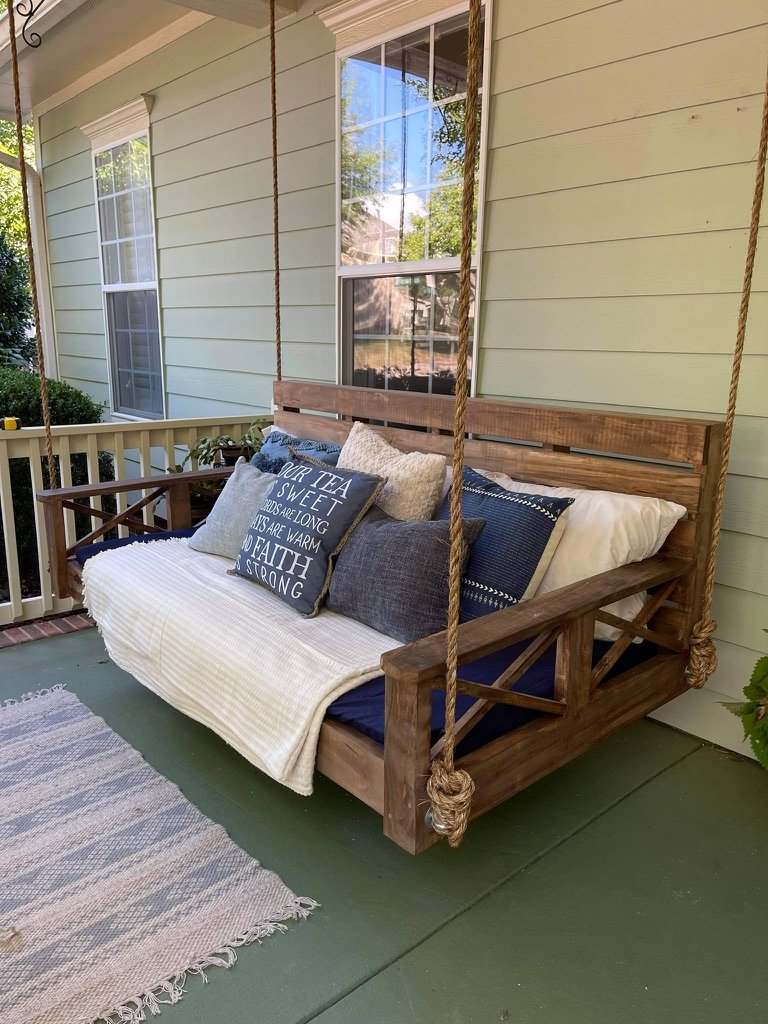 Porch swing with blue pillows